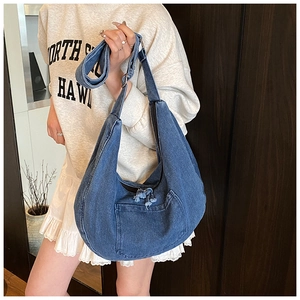 Detail of the blue denim hobo bag featuring frayed edges and a large front pocket