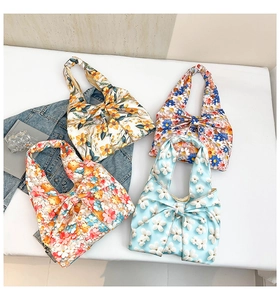 Flache Ansicht von vier floralen Taschen in Schleifenform in Blau, Weiß und Orange