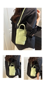 Dettaglio mini borsa a tracolla verde menta con logo FASHION & BAGS e ciondolo a cane