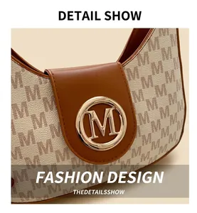 Gros plan détaillé du sac porté épaule vintage avec logo doré et finitions en cuir marron