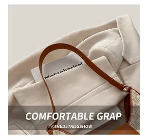 Gros plan du sac porté épaule vintage avec poignée en cuir marron et anneaux métalliques