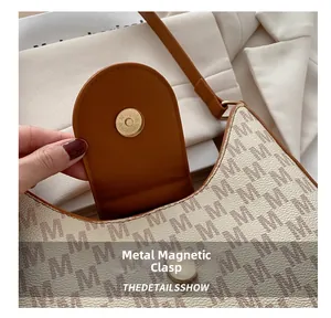 Gros plan du fermoir magnétique en métal d'un sac à bandoulière vintage à monogramme