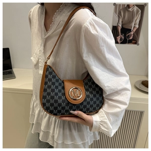 Détail du sac porté épaule rétro avec toile monogrammée M et finitions en cuir marron