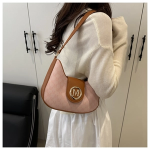 Vue détaillée du sac hobo rose avec bordure marron et boucle en métal dorée avec lettre M