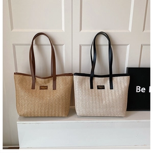 Gros plan de sacs cabas en paille tressée beige et marron avec anses en similicuir