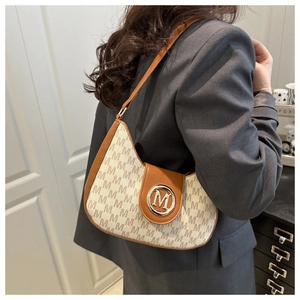 Détail du sac à bandoulière vintage avec logo imprimé et boucle M dorée sur toile