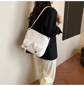 Modern white PU leather tote bag shown on shoulder with stylish dual front pocket details