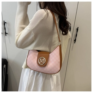 Détail d'un sac hobo rose à monogramme avec finitions en cuir brun et boucle dorée M