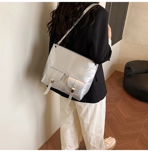 Detail of silver metallic tote bag featuring dual cargo pockets and sleek strap design