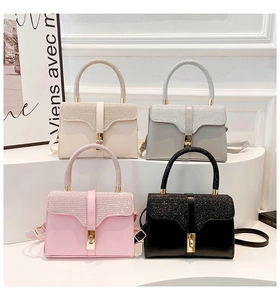 Detail showing four assorted colors of glittery leather mini handbags on white steps