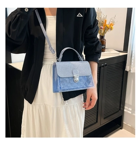 Détail du sac jelly bleu clair avec texture géométrique et fermoir argenté sur mannequin