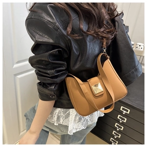 Chic tan faux leather crescent bag with gold buckle on a model in a black jacket
