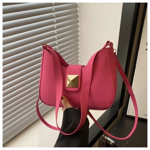 Detail of fuchsia half-moon bag with golden pyramid metal buckle and smooth PU finish
