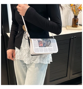 Détail d'un sac bandoulière blanc avec imprimé journal vintage et fine bandoulière