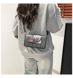Détail du sac bandoulière imprimé journal avec graphiques rétro et logo Red Abbles