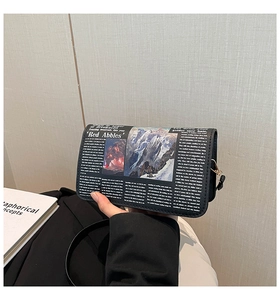 Détail de l'imprimé journal rétro sur le sac bandoulière noir avec boucle dorée