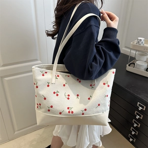 Sac fourre-tout en velours côtelé avec imprimé cerise porté par un mannequin