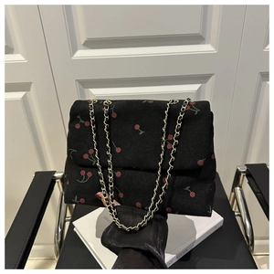 Détail du sac cabas en velours côtelé noir avec imprimé cerises et chaîne dorée