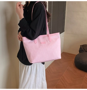Detailed close-up of pink woven texture on large tote bag with elegant shoulder strap