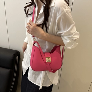 Minimalist fuchsia leather crossbody saddle bag with gold metal rivet on modern model