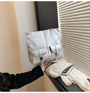 Détail du sac à bandoulière argenté métallisé avec deux poches et boucles décoratives