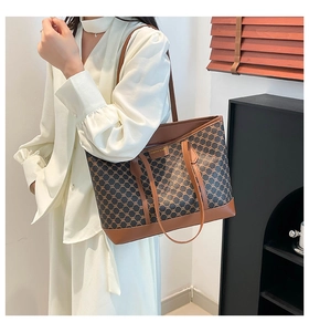 Close-up of vintage chain-link pattern tote bag with brown leather trim and metal logo