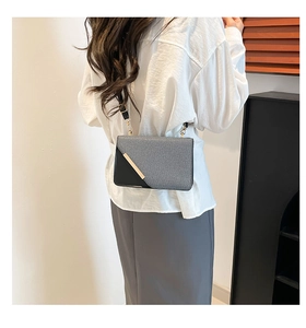 Détail du sac bandoulière en tissu gris et cuir noir avec bordure en métal doré