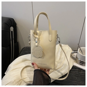Chic beige crossbody phone bag with dog charm and fashion text on wooden table