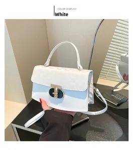 Detailed close-up of white crossbody bag with patterned flap and metallic clasp