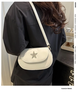 White semi-circular crossbody bag with silver star detail worn by model at the back