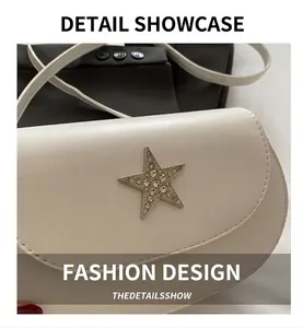 Close-up of white saddle bag featuring a rhinestone star buckle and precise stitching