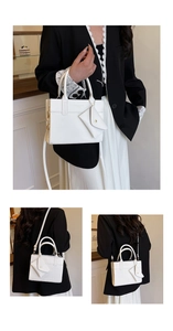 Detail of white crossbody bag featuring a small hanging pouch and golden hardware