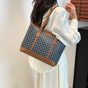 Large capacity grey monogram tote bag with brown leather handles and gold logo detail
