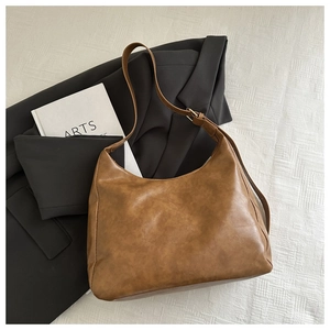 Detail of caramel brown hobo bag with adjustable strap and vintage texture leather