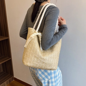 Straw woven tote bag with white rope straps and lace bow decoration for summer