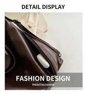 Détail de la poche latérale zippée sur sac à dos en cuir marron avec écouteurs
