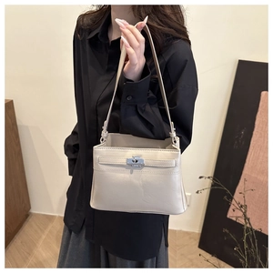 Detail of cream leather handbag with silver metallic twist lock and decorative straps