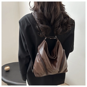 Détail d'un sac à dos vintage marron foncé avec fermetures éclair latérales uniques