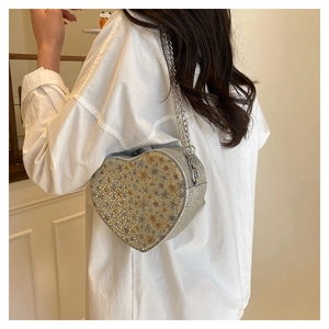Close-up of heart-shaped sequin shoulder bag with elegant silver chain strap