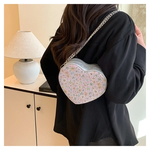 Detailed back view of a heart shaped crossbody bag with floral sequins and silver chain