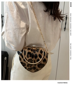 Macro shot of heart-shaped leopard print bag featuring a large rhinestone lock and gold chain
