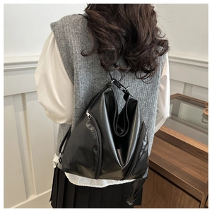 Détail d'un sac à dos en similicuir noir avec coupe triangulaire et double zip métallique