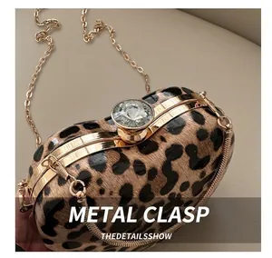 Detail of leopard print hard shell clutch with crystal ball clasp and gold chain
