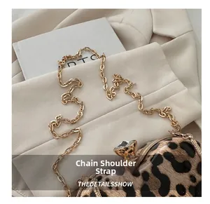 Detail of leopard print bag with gold chain and large crystal lock on white blazer