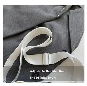 Detail of adjustable white nylon shoulder strap with silver buckle on fashion crossbody bag