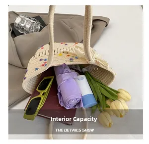Straw bucket bag with pom-poms and lace detail showing large interior storage capacity