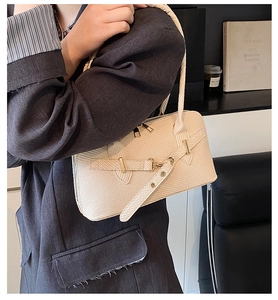 Close-up of cream woven texture handbag with golden buckle for casual commute look