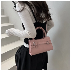 Pink bow-knot handbag with silver buckle and adjustable strap on a female model