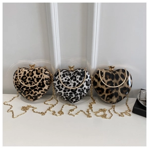 Detailed view of three heart-shaped leopard print bags with gold metal frame and chain
