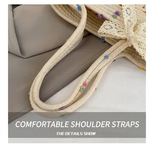 Detail of woven straw bucket bag with colorful pom-poms and lace bow on comfortable strap